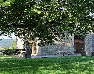 Schaduwrijke tuin met zitplaatsen bij La Chapelle 10, vakantiehuis in Lierneux, Ardennen, Belgi, omringd door natuur.
