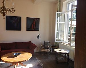 Lichte binnenruimte van Huisje in Mortier, vakantiehuis in de Ardennen, Luik, Belgi, met comfortabele zitplaatsen en kunst aan de muur.