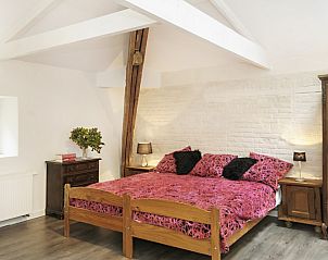 Comfortabele slaapkamer in La Divine Providence vakantiehuis in Wodecq, Henegouwen met houten balken.