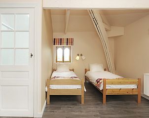 Knusse tweepersoonskamer in La Divine Providence vakantiehuis in Wodecq, Henegouwen met houten details.