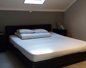 Knusse slaapkamer in Bij Andy, Mont- de l'enclus, Henegouwen, Belgi met minimalistische inrichting en gezellig dakraam.