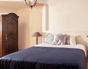 Comfortabele slaapkamer in Brasserelles - gte rural, Elzele, Henegouwen met antieke kast en kroonluchter.