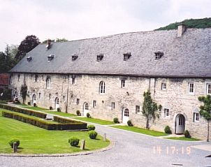 Historische gevel van Ferme de l'Abbaye de Moulins, vakantiehuis in Anhe, Ardennen, met prachtige stenen muren en verzorgde tuinen.