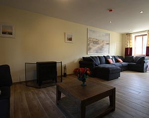 Gezellige woonkamer in Vakantiehuis in Furnaux, Ardennen, Belgi met comfortabele zithoek en natuurlijk licht.