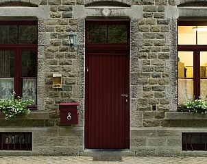 Charming cottage House in Purnode, located in the Ardennes, Belgium, with rustic stone facade and inviting red door.