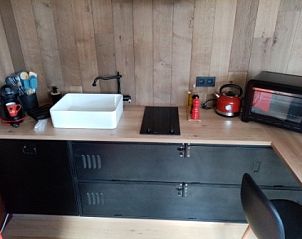 Moderne keuken in Le Wagon vakantiehuis, Graide, Ardennen, Belgi met houten afwerking en stijlvolle apparatuur.