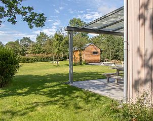 Ruime tuin met veranda bij Le Refuge Du Renard vakantiehuis in Hour, Ardennen, perfect voor ontspanning.