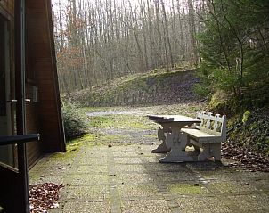 Rustieke stenen bank op het terras van Chalet Dion, Beauraing, Ardennen, in een serene omgeving.