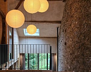 Bovenverdieping van La Charpente, vakantiehuis in Gros-Fays, Ardennen, met zicht op natuur door grote ramen.