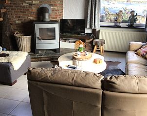 Gezellige woonkamer van Maison Franz bungalow in Achouffe, Ardennen met houtkachel en comfortabele banken.
