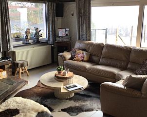 Lichte leefruimte in Maison Franz bungalow, Achouffe, Ardennen met grote ramen en uitzicht op de natuur.