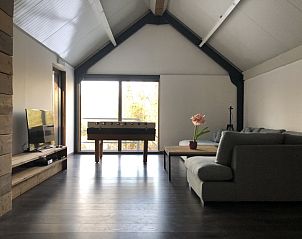 Zitkamer met tafelvoetbal in De Meute vakantiehuis, Vielsalm, Ardennen met uitzicht op de tuin.