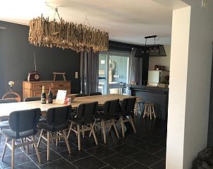 Dining room of Les Hirondelles de Durbuy in Durbuy, Ardennes, with long wooden table and modern decor.