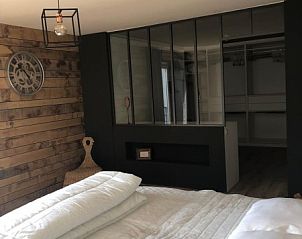 Master bedroom of Les Hirondelles de Durbuy in Durbuy, Ardennes, with luxurious bed and wooden details.