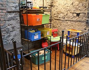 Speelruimte in Les Trois Sangliers vakantiehuis, Chanly, Ardennen, met kleurrijk speelgoed en stenen muren.