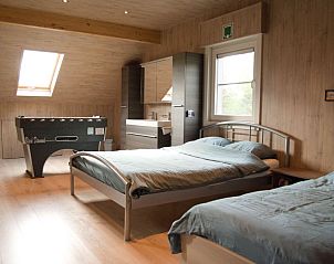 Slaapkamer met twee bedden en tafelvoetbal in Maison 12ment, vakantiehuis in Durbuy, Ardennen, ideaal voor ontspanning.