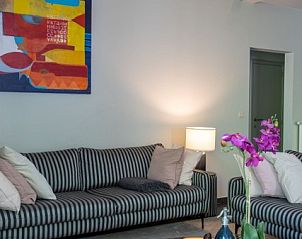 Gezellige woonkamer in La Roche Durbuy vakantiehuis met kleurrijke kunst en comfortabele banken.