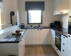 Moderne keuken in Dogo In Paradise vakantiehuis, Houffalize, Ardennen, met wit interieur en houten vloer.