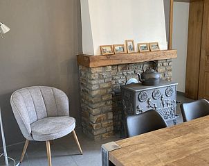 Cozy living room in Cottage in Samre, Ardennes, with rustic fireplace and comfortable seating area.
