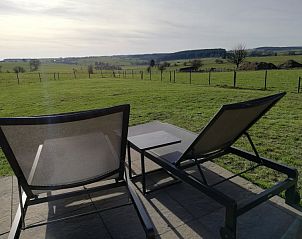 Relaxen op ligstoelen met uitzicht op de Ardennen bij Maison de l'amiti, vakantiehuis in Houffalize, Belgi.