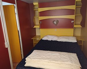 Sfeervolle slaapkamer in een stacaravan in Viareggio, Toscane, Itali, met levendige kleuren en een uitnodigend bed voor ultiem comfort.