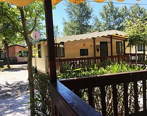 Ontspan op het terras van Chalet Toskane aan zee, een sfeervolle stacaravan in het groene Viareggio, Toscane.