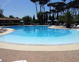 Geniet van het zwembad bij Chalet Toskane aan zee, een stacaravan in Viareggio, Toscane, met ligstoelen en serene omgeving.