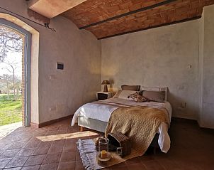 Comfortabele slaapkamer in Casale LA MEMORIA, vakantiehuis in Saturnia, Toscane, met warme tinten en toegang tot natuurlijke omgeving.