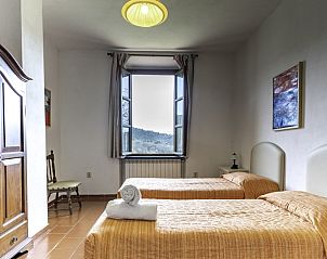 Slaapkamer met twee bedden in Alfoionco vakantiehuis, San Macario, Toscane, met een schilderachtig uitzicht.