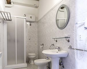 Badkamer van vakantiehuis Alfoionco in San Macario, Toscane, met een rustiek houten plafond en moderne voorzieningen.