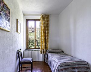 Kleine slaapkamer in Alfoionco, San Macario, Toscane, vakantiehuis met eenpersoonsbed en tuinzicht.