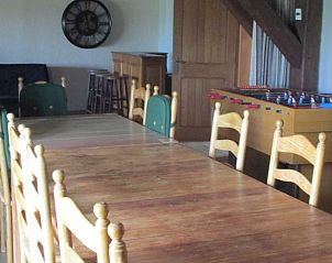 Gezellige binnenruimte van Huisje in Anloy, vakantiehuis in de Ardennen, Belgi, met houten eettafel en tafelvoetbal voor familietijd.