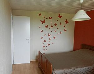 Sfeervolle slaapkamer in Huisje in Anloy, vakantiehuis in de Ardennen, Belgi, met vlinderdecoratie op de muur.