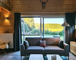 Lichte woonkamer van Chalet Cervo in Samre, La Roche-en-Ardenne, met uitzicht op de groene omgeving van de Ardennen, Belgi.