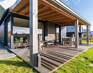 Ruime veranda van Huisje in Sint Nicolaasga met comfortabele zitruimte, ideaal voor ontspanning.