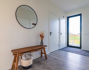 Inkomhal van Vakantiehuisje in Sint Nicolaasga met houten bank en moderne inrichting, Friese meren.