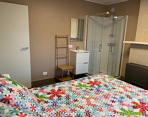 Slaapkamer met kleurrijk beddengoed in Vakantiehuis RUST, Middelkerke, Belgische kust, en moderne inloopdouche.