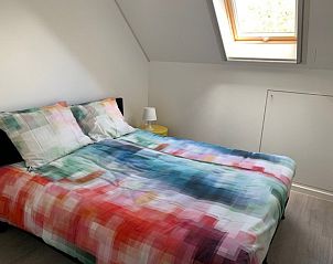 Comfortabele slaapkamer met kleurrijk beddengoed in Vakantiehuis RUST, Middelkerke, Belgische kust.