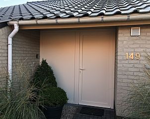 Ingang van vakantiehuis Zee en Polder in Westende aan de Belgische kust, met moderne gevel en groene planten.