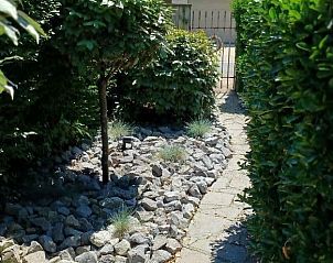 Pittoreske tuinpad bij Vakantiewoning Westende-Bad, omgeven door groene natuur in Westende, Belgi.