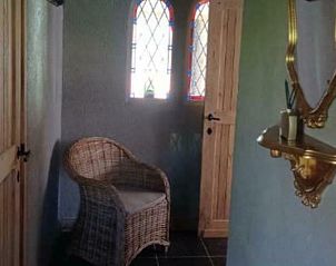 Gezellige entree van Vakantiewoning Westende-Bad met rieten stoel en decoratieve elementen, gelegen in Westende.