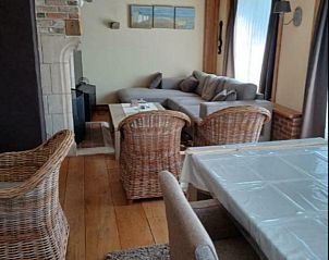 Woonkamer van Vakantiewoning Westende-Bad met rieten stoelen en open haard, gelegen in Westende, Belgi.