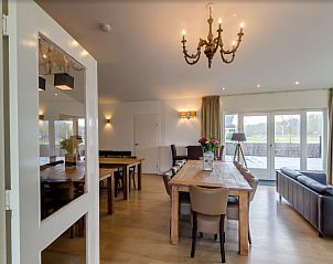 Open eet- en woonkamer in La Cabane parterre, vakantiehuis aan zee, Belgische kust, Belgi met veel lichtinval.