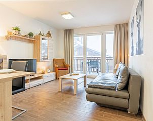 Stijlvolle woonkamer van Emma Top 2, vakantiehuis in Dienten, Salzburg, met toegang tot balkon en natuur.