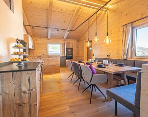 Binnenruimte van chalet Siedelhtte in Gerlos, Tirol, met warme houten afwerking en ruime eetgelegenheid.