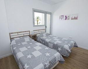 Gezellige slaapkamer in El Mirador de Calpe, vakantieappartement in Calpe, Costa Blanca, met uitzicht op een palmboom.