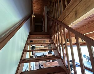 Wooden staircase in Cottage in Gongahuizen, vacation home in Pikmeer, Frisian Lakes, leads to upper floor.