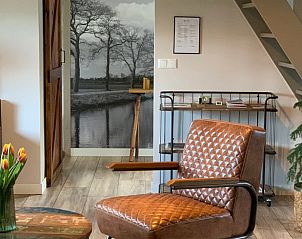 Stijlvolle woonkamer in Vakantiehuis in Beilen, Midden Drenthe met leren stoel.
