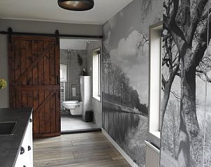 Sfeervolle hal met houten schuifdeur in Vakantiehuis in Beilen, Midden Drenthe.