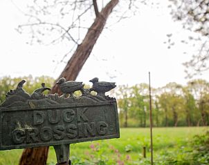 Landelijk bord bij Vakantiehuis in Geeuwenbrug, Drenthe, met groene omgeving.